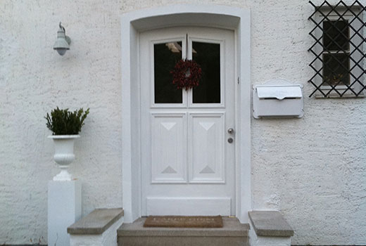 Einladendende Haustür mit eingearbeiteten Fenstern und Verzierungen. 